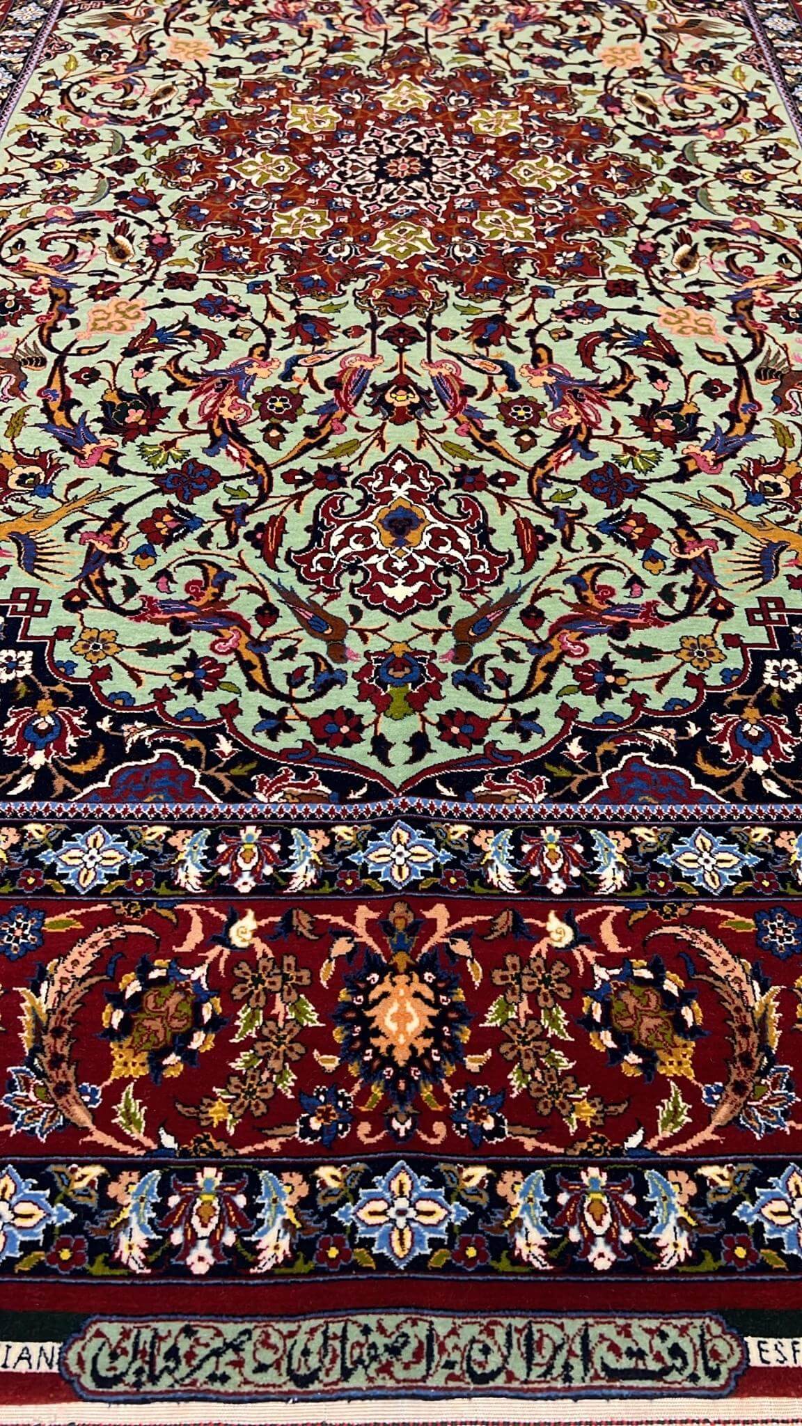 "Close-up of the Seirafian hand-knotted Persian rug with vibrant green and red tones, crafted in Isfahan."